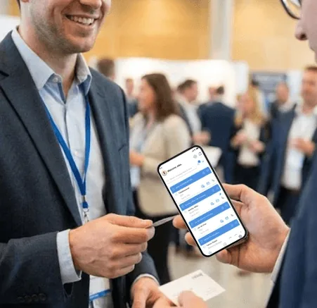 Business professionals networking at an event using an AI-powered business card scanner app to digitize and manage contacts.